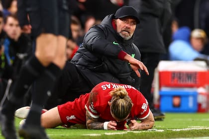 Jurgen Klopp y Konstantinos Tsimikas, jugador de Liverpool, en el piso, luego del choque involuntario que terminó con el defensor lesionado