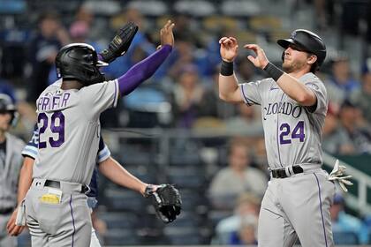 Jurickson Profar (29) y Ryan McMahon (24), de los Rockies de Colorado, celebran después de anotar con doble de Elías Díaz durante la octava entrada del juego de béisbol en contra de los Reales de Kansas City, el viernes 2 de junio de 2023, en Kansas City, Missouri. (AP Foto/Charlie Riedel)