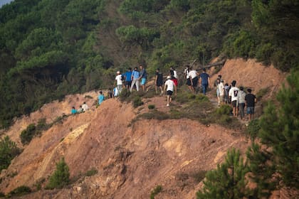 Jvenes marroquíes se abren paso en una zona escarpada cerca de Fnideq para entrar a Ceuta