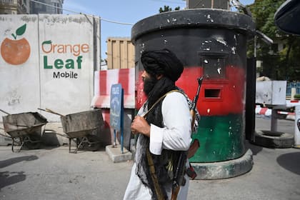 A Taliban fighter patrols along a street in Kabul on August 17, 2021, as the Taliban moved quickly to restart the Afghan capital following their stunning takeover of Kabul and told government staff to return to work. (Photo by WAKIL KOHSAR / AFP)