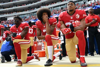 Colin Kaepernick (centro), de rodillas durante el himno que pasó en silencio y marcó un hito en la lucha contra la violencia racial.