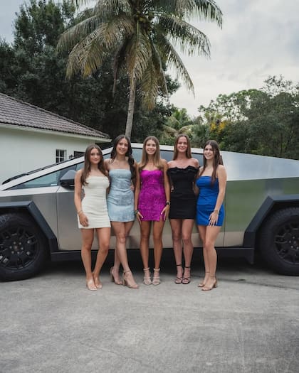 Kai Trump y sus amigas junto a un Tesla.