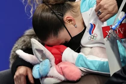 Kamila Valieva, de 15 años, llora abrazada a su conejo de peluche al recibir el puntaje que la ubica en el cuarto lugar de la competencia por fuera del medallero