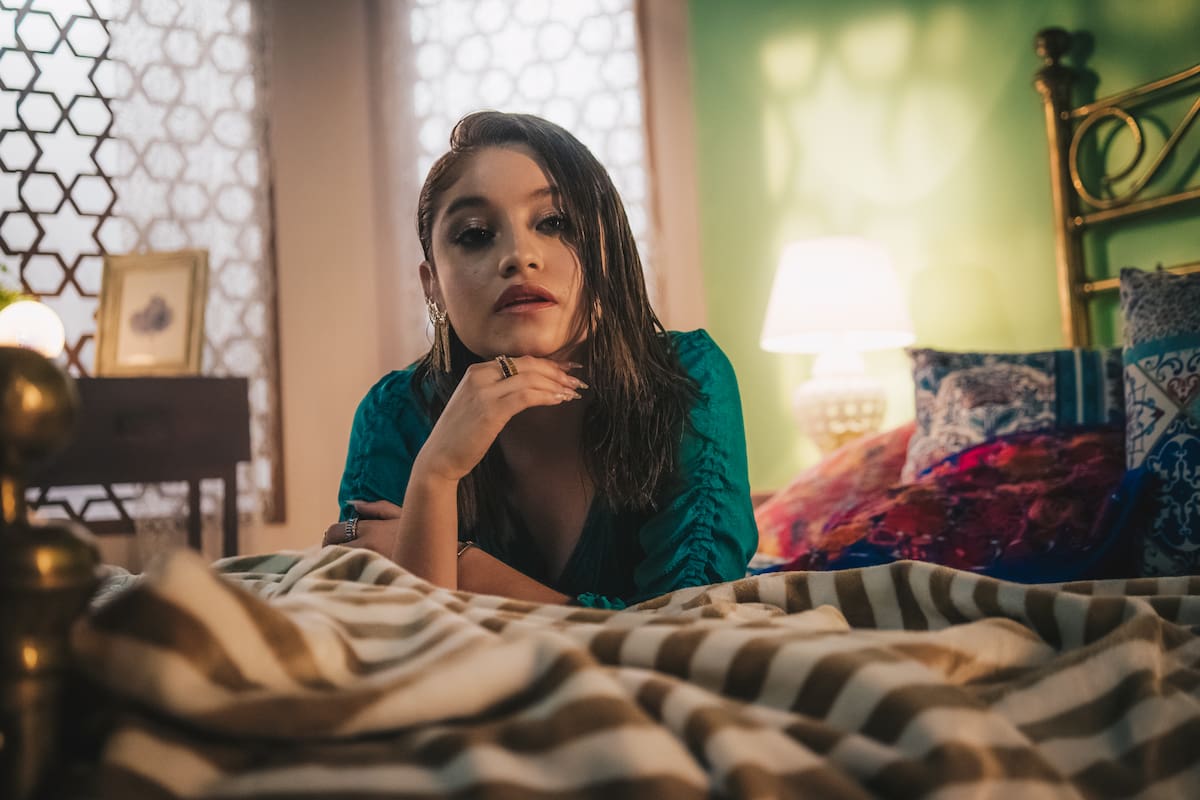 Karol Sevilla recostada sobre una cama
