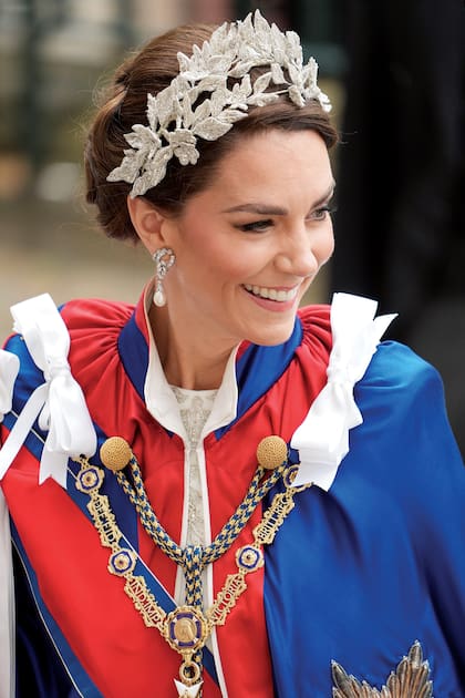 Kate lució los pendientes de perlas y diamantes que pertenecieron a su suegra, Diana de Gales. La joya se llama Herradura y Laurel. Además, sumó un tocado de Jess Collett x Alexander McQueen con lingotes de plata, cristal y bordado de hojas tridimensionales con hilo de plata.