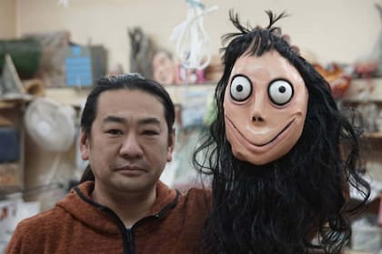 Keisuke Aiso, el artista de la escultura conocida bajo el nombre de Momo, posa con la máscara que un amigo le trajo de México, uno de los países donde comenzó el reto viral Momo Challenge