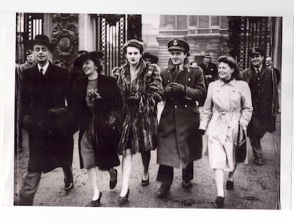 Kenneth Charney ingresa el Palacio de Buckingham para recibir su barra a su Cruz de Vuelo Distinguido luego de su épico combate aéreo sobre Normandía. Lo acompañan el diplomático argentino, embajador en Londres Dr. Miguel Angel Carcano, la madre de Charney, su hermana Pamela y Moira Benitz, voluntaria rosarina en la guerra que prestó servicios en la BBC de Londres. (Archivo Claudio Meunier).
