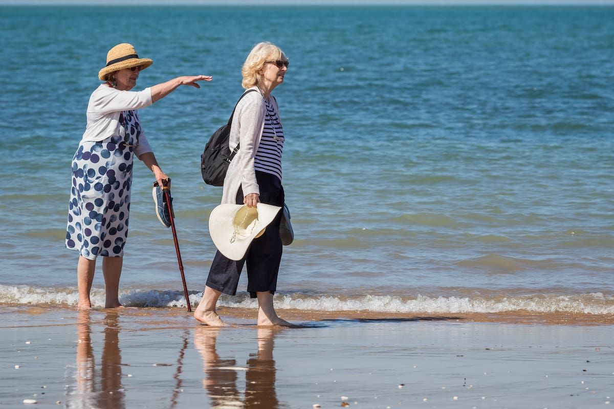 Kent, England - 14 June, 2022 - Two senior women enjoy walking on the beach at Botany Bay in the seaside town of Broadstairs