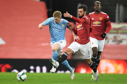 Kevin De Bruyne, de Manchester City, contra Bruno Fernandez, de Manchester United; completa la escena Paul Pogba.