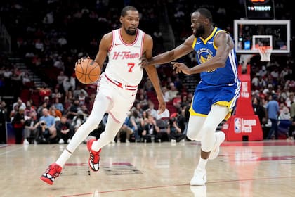 Kevin Durant (7), alero de los Rockets de Houston, dribla mientras Draymond Green, alero de los Warr