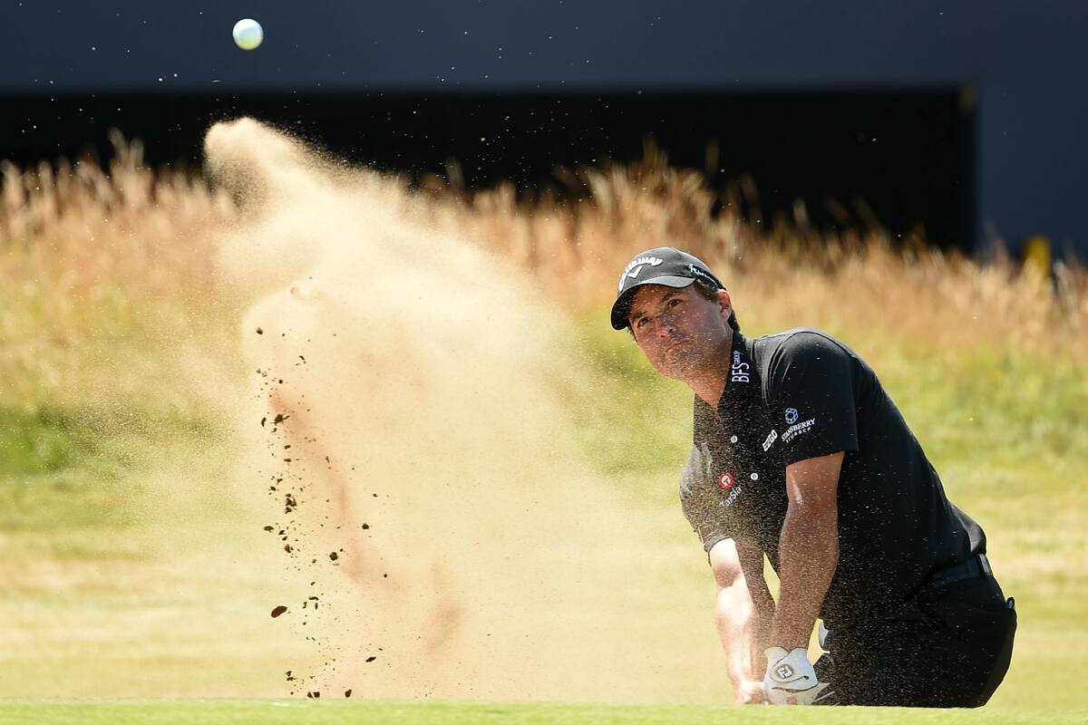 Kevin Kisner sale del bunker del hoyo 18 en el primer día del British Open en Carnoustie