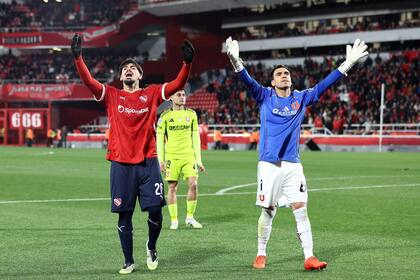 Kevin Lomónaco, defensor de Independiente, y Cristopher Toselli, arquero de Universidad de Chile, anoche, intentando calmar a los hinchas en medio de los incidentes
