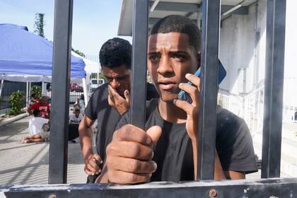 Kevin Perez de Matanzas, Cuba, llama a su abuela desde una instalación la Oficina de Aduanas y Protección Fronteriza de Estados Unidos el jueves 5 de enero de 2023, en Marathon, Florida. (AP Foto/Marta Lavandier)