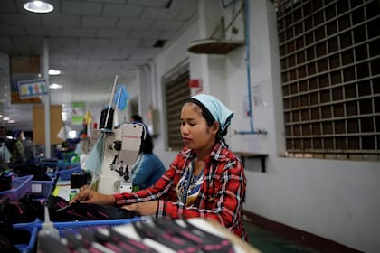 Khen Srey Touch, de 27 años, que está embarazada de nueve meses, cose calzado en el trabajo en Complete Honor Footwear Industrial