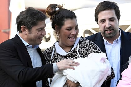 El gobernador Axel Kicillof y el ministro Nicolás Kreplak, con una beneficiaria del Plan Qunita y su bebé