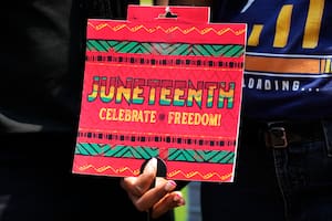 Kimberly Thomas sostiene un cartel antes de un partido de béisbol entre los Orioles de Baltimore y los Cachorros de Chicago, en Chicago, el domingo 18 de junio de 2023. (Foto AP/Nam Y. Huh)