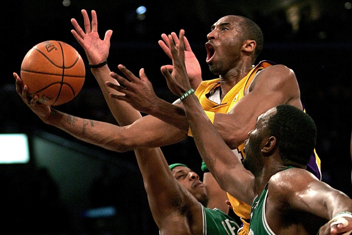 Kobe Bryant de Los Angeles Lakers, arriba, sube para un tiro entre Paul Pierce de Boston Celtics, izquierda, y Al Jefferson durante la primera mitad de un juego de baloncesto de la NBA en Los Ángeles, 23 de febrero de 2006