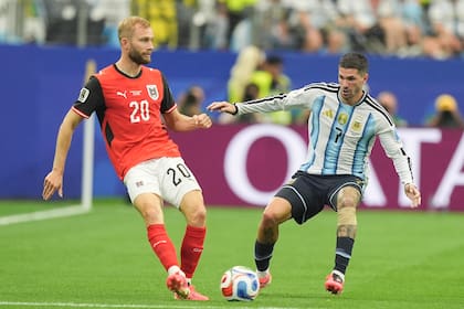 Konrad Laimer disputa la pelota con Rodrigo De Paul