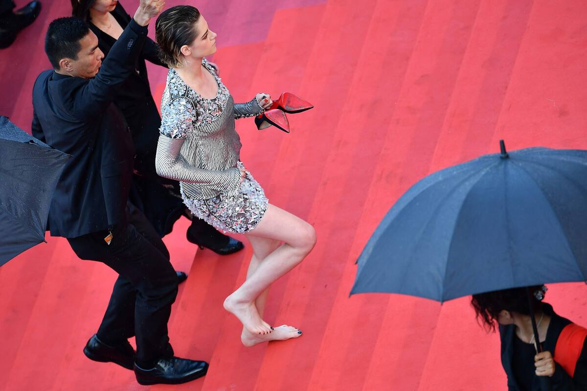 Kristen Stewart, con los zapatos en la mano, sube las escalinatas rumbo a la sala de cine