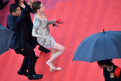 Kristen Stewart, con los zapatos en la mano, sube las escalinatas rumbo a la sala de cine