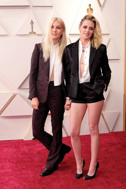 Kristen Stewart, nominada como Mejor Actriz por su interpretación de Diana de Gales en Spencer, demostró una vez más su rebeldía desacatando el dress code que marcaba “por debajo de la rodilla”. Eligió un conjunto de chaqueta y micro shorts de Chanel, que acompañó con una blusa prácticamente sin abrochar y stilettos. La acompañó su prometida, Dylan Meyer.