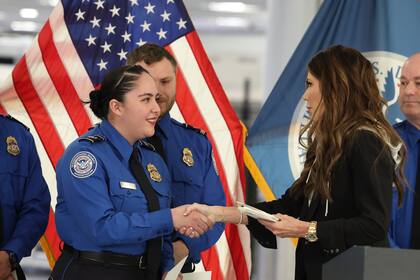 Kristi Noem estrecha la mano de una funcionaria de la Administración de Seguridad en el Transporte en el aeropuerto Harry Reid, el 22 de noviembre de 2025, en Las Vegas