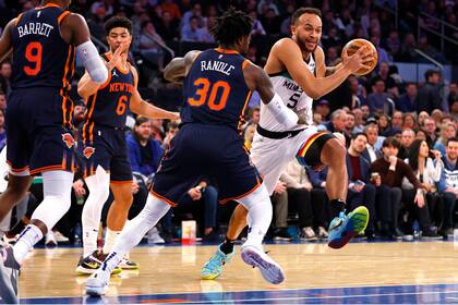 Kyle Anderson (5), de los Timberwolves de Minnesota, conduce el balón y encara a Julius Randle (30), de los Knicks de Nueva York, durante la primera mitad del juego de baloncesto de la NBA, el lunes 20 de marzo de 2023, en Nueva York. (AP Foto/Noah K. Murray)