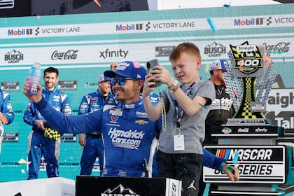 Kyle Larson celebra con su hijo Owen después de conseguir la victoria en la Cup Series de NASCAR en el Homestead-Miami Speedway, en Homestead, Florida, el domingo 23 de marzo de 2025 (AP Foto/Terry Renna)