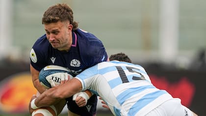 Kyle Rowe avanza con la pelota y lo tacklea Santiago Carreras