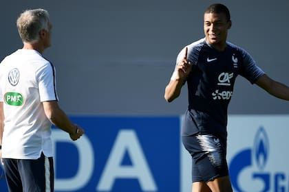 Kylian Mbappé durante una práctica de Francia, en pleno diálogo con el DT, Didier Deschamps