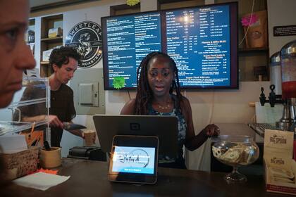 Kymme Williams-Davis toma un pedido en su cafetería Bushwick Grind Cafe, el 8 de septiembre de 2022 en Nueva York. (Foto AP/Bebeto Matthews)