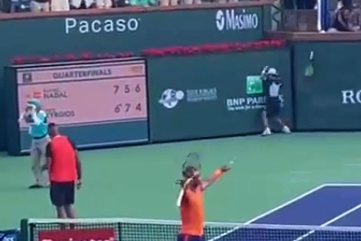 Kyrgios, de espaldas, ya lanzó su raqueta, que dio contra el piso, se levantó y cayó a centímetros del ball boy que estaba contra la pared