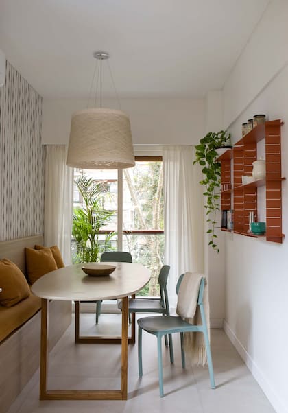 l comedor diario, se diseñó un banco a medida y una mesa con patas en petiribí y tapa ovalada en microcemento (Estudio MMC). Sillas (Landmark).