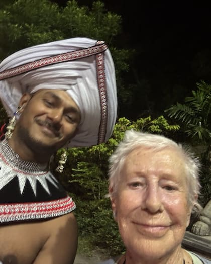 La abuelita mochilera junto a uno de los bailarines que la recibieron al llegar a Sri Lanka (Foto: Instagram/@abuelitamochilera)