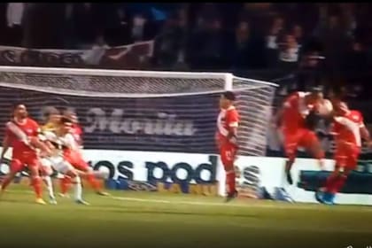 La acción de la polémica: tras el tiro libre de Delgadillo, la pelota da en la cabeza y de inmediato en la mano de Galarza, que estaba en la barrera. Falcón Pérez no revisó la jugada y terminó el cotejo