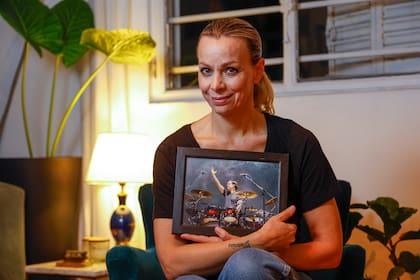 La actriz Cecilia "Caramelito" Carrizo posa en su hogar con una foto del recordado baterista Martín Carrizo, su hermano, a quien le dedica una obra que estrena este mes en el Teatro Picadero