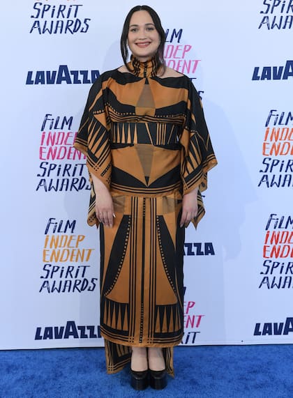 La actriz Lily Gladstone sorprendió con un vestido de estilo étnico que combinó el negro y el marrón de mangas abiertas, falda asimétrica y un cuello alto con cut out. Completó el look con zapatos de plataforma