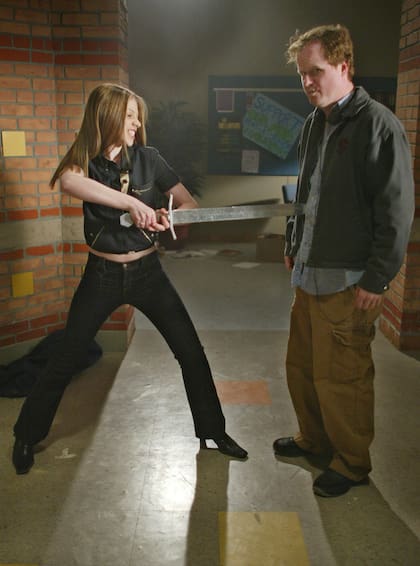 La actriz Michelle Trachtenberg, izquierda, que interpreta a Dawn -la hermana de Buffy, Emmy- juega con el productor y creador de la serie Joss Whedon, durante la grabación del episodio final de "Buffy the Vampire Slayer" en Santa Mónica, California, el 16 de abril de 2003. (Foto AP/Damian Dovarganes, archivo)