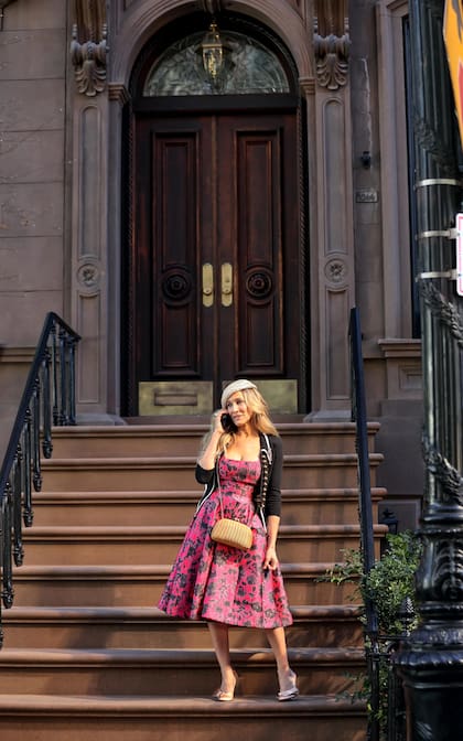 La actriz Sarah Jessica Parker saliendo del edificio que representa el hogar de su personaje en la serie
