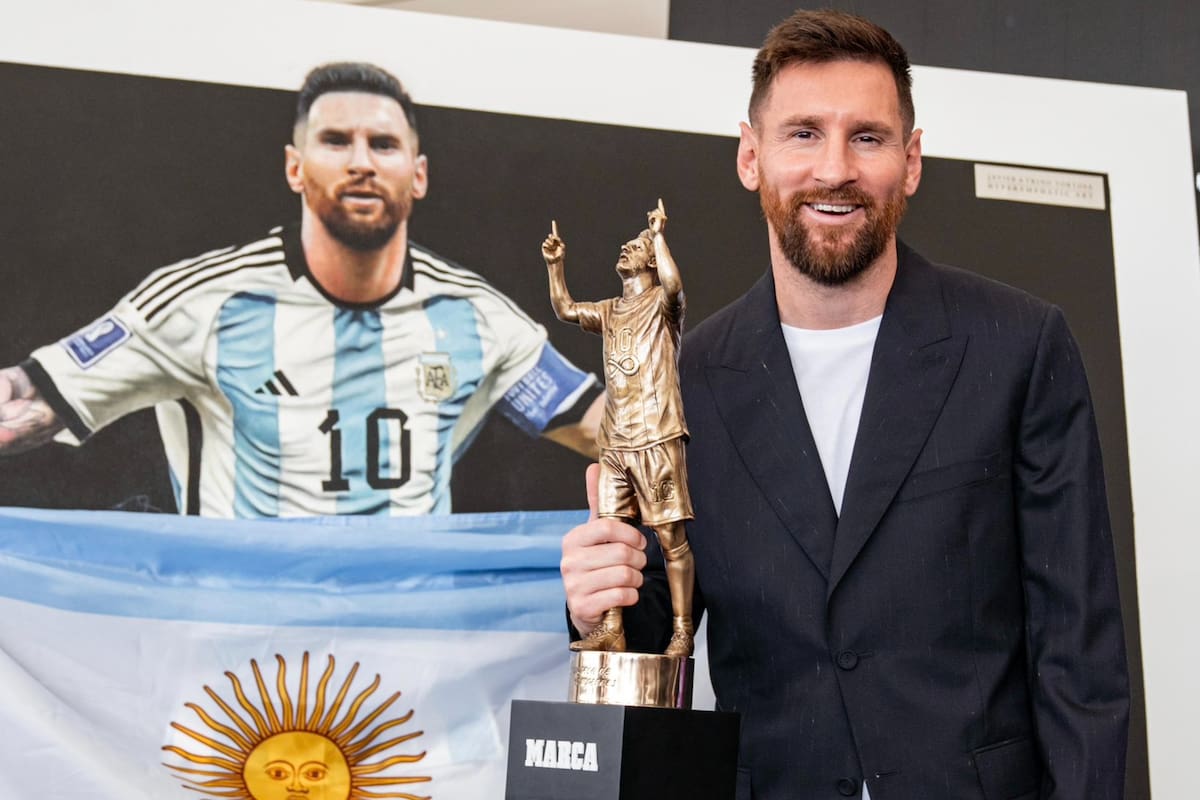 La alegría de Lionel Messi por otro reconocimiento, con el trofeo de Marca y el cuadro con la bandera detrás.