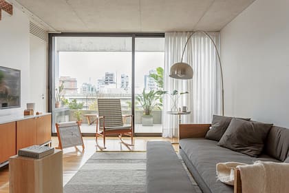 Sillón ‘Petiso’ de 2x1,20m con estructura de madera y apoyapiés (Helmut) tapizado (Fluoh Objetos Textiles). Alfombra a rayas (Elementos Argentinos).