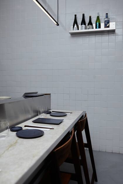 La ambientación descansa en el minimalismo japonés: una barra de acero inoxidable y cuarcita invita a la experiencia.