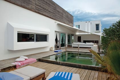 La ampliación se dio en las plantas altas: en el volumen de la derecha, se hizo una nueva suite; en el que está más en primer plano, se hizo un playroom. Larga y apaisada, una de las ventanas del living se proyecta sobre el deck.