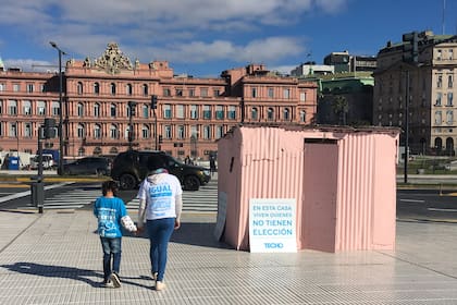 La "casilla rosada", que se instaló en el Paseo del Bajo, justo atrás de la Casa Rosada, simboliza la realidad de miles de familias en los barrios populares de nuestro país