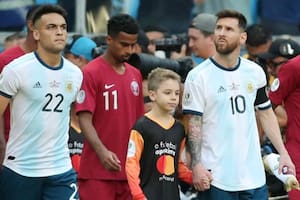 La "mascota" Tomás Chávez, oriundo de Posadas, de la mano de Lionel Messi antes del partido con Qatar del último domingo; a su lado, Lautaro Martínez