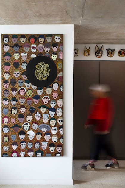 La artista con su obra y unas máscaras Chané encima.