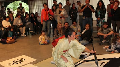La artista Julieta Jiterman, pintando un ideograma en el Jardín japonés