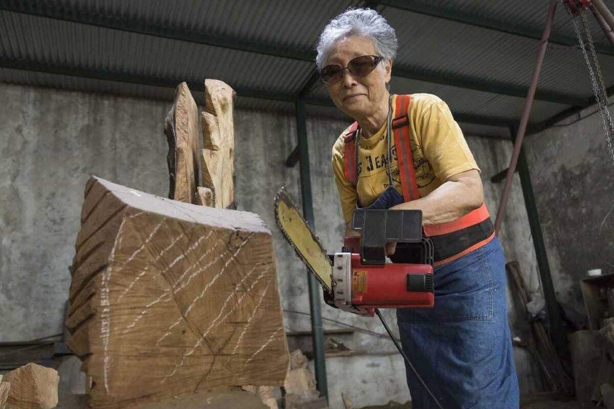 La artista trabaja con su motosierra