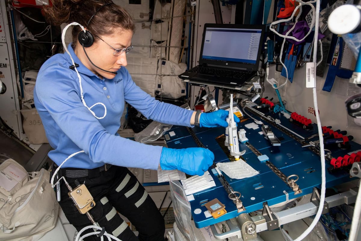 La astronauta de la NASA Christina Koch durante el proceso de secuenciamiento de ADN desde la Estación Espacial Internacional, un proceso que IBM busca acelerar con un procesamiento en el sitio mediante técnicas de edge computing