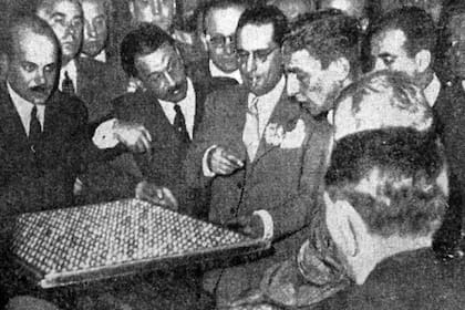 El juez Vázquez observa una de las bandejas de las bolillas en la reconstrucción del affaire de los niños cantores, en LA NACION del 10 de septiembre